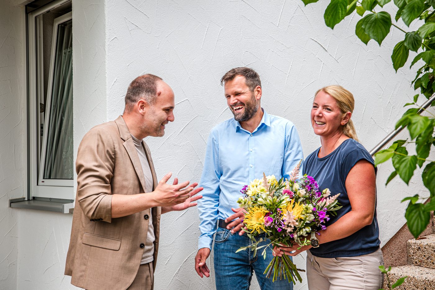 Jan Pussert überreicht Melanie und Jens einen Blumenstrauß vor ihrem Haus in Beiersdorf