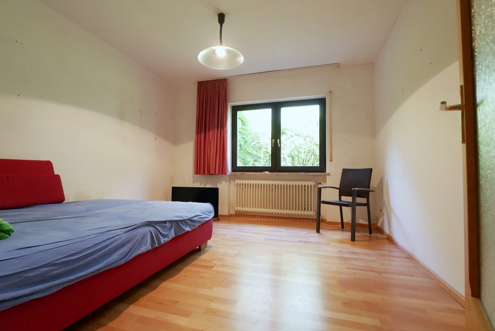 Arbeitszimmer vor dem Home Staging: Bett mit blauem Laken, Stuhl und leere Wände