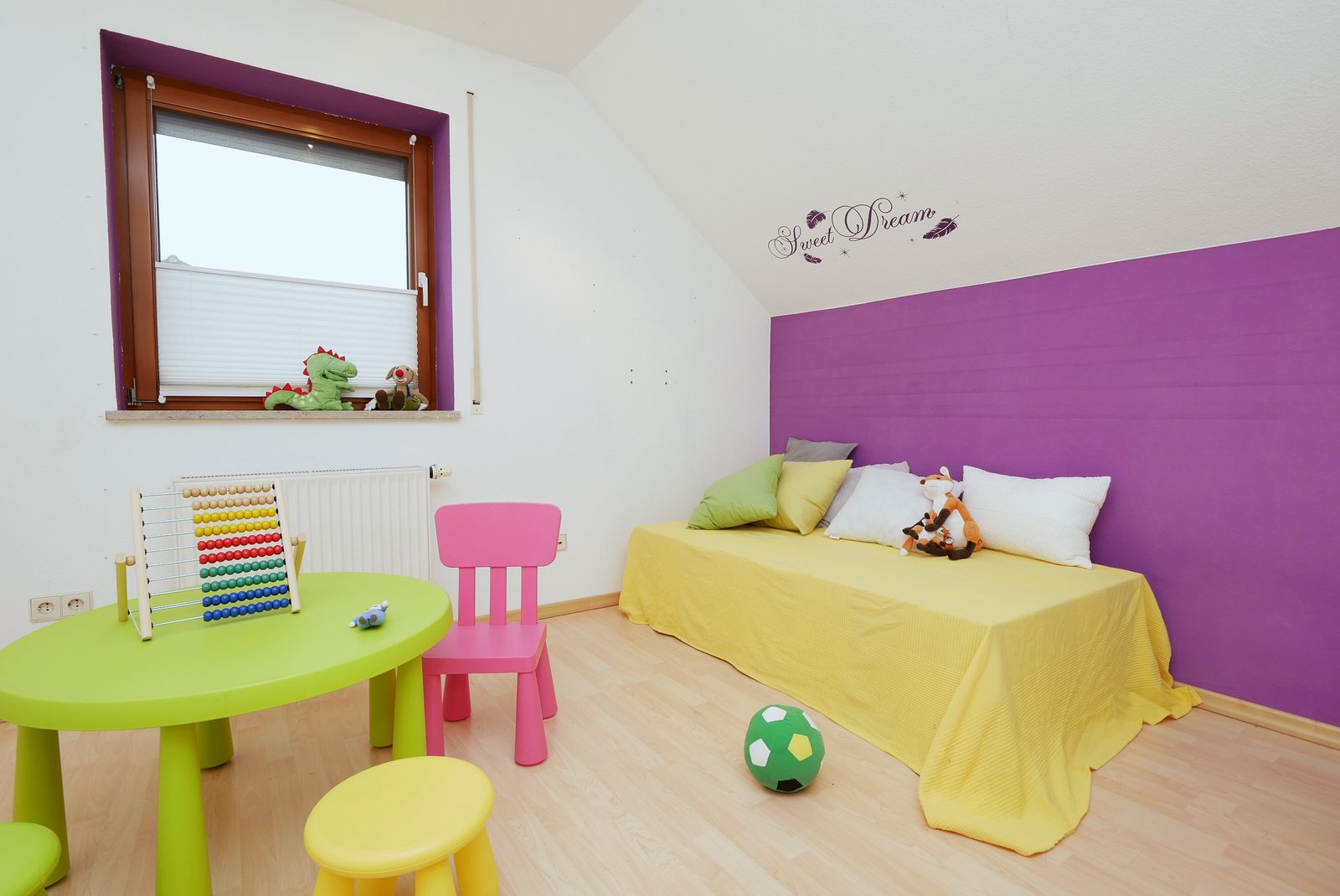 Kinderzimmer nach dem Home Staging: Bett mit gelber Decke, Kindertisch und Spielzeug