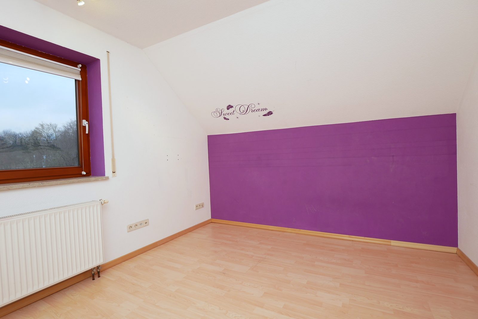 Kinderzimmer vor dem Home Staging: leerer Raum mit lila Wand