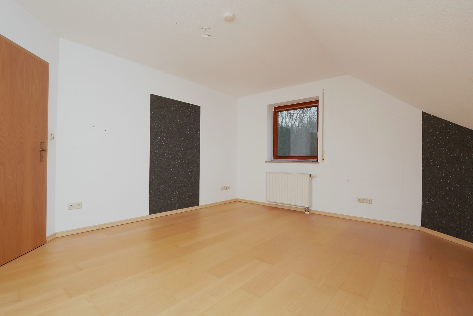 Schlafzimmer vor dem Home Staging: leerer Raum mit Parkett und Dachschräge