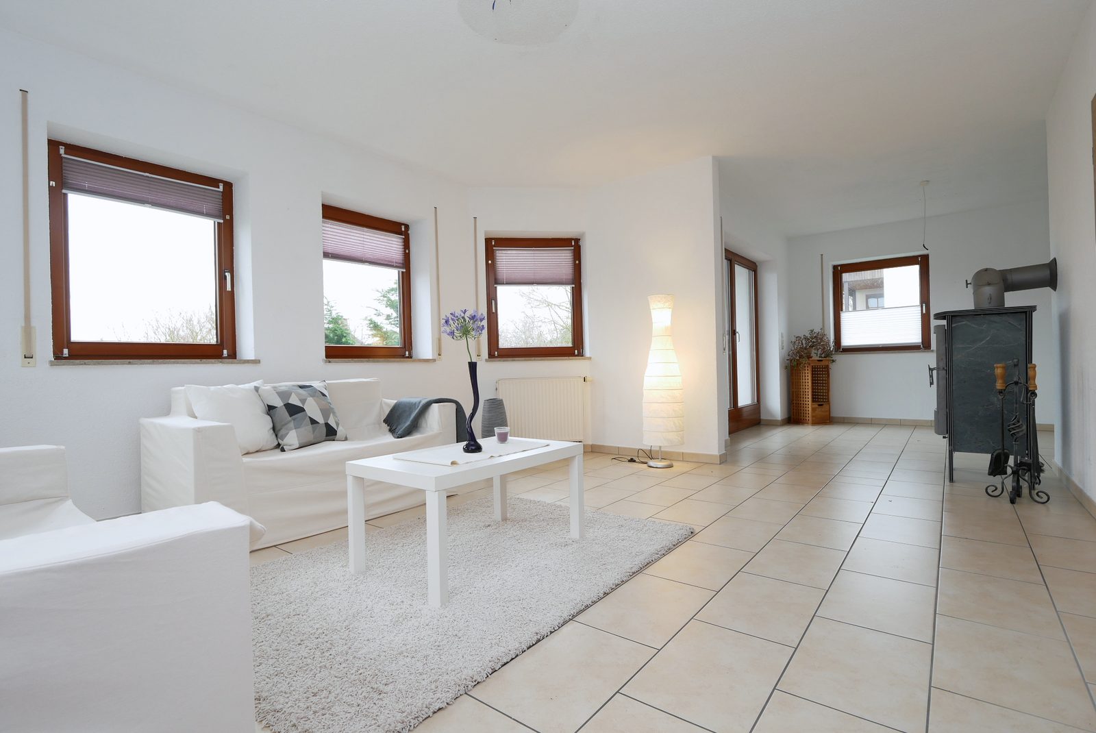 Wohnzimmer nach dem Home Staging: helles Sofa, Teppich, Couchtisch und Stehleuchte